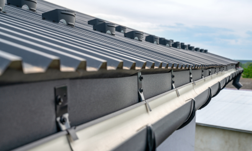 A close up of a metal roof with gutters.