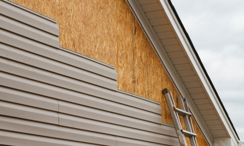 Brown vinyl siding being applied to a home.