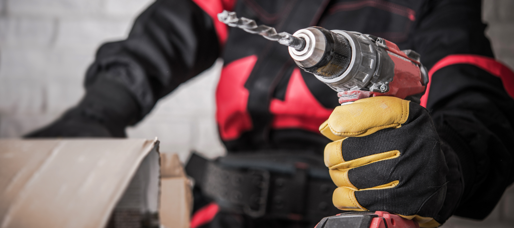 A contractor holding a red power drill.